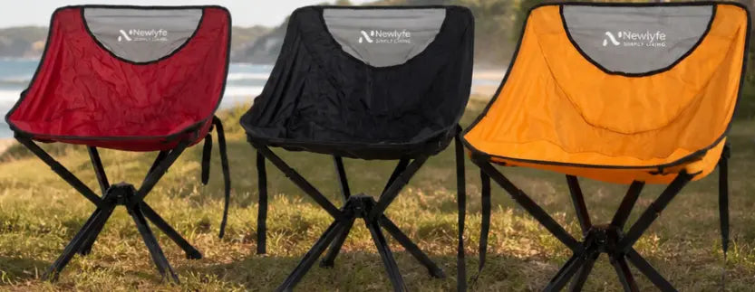 three compact camping chairs set up at an Australian beach by a caravan